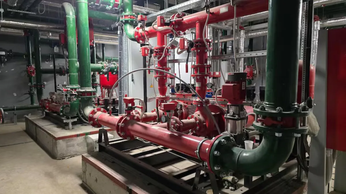 Large red and green piping and pumps in a commercial mechanical room