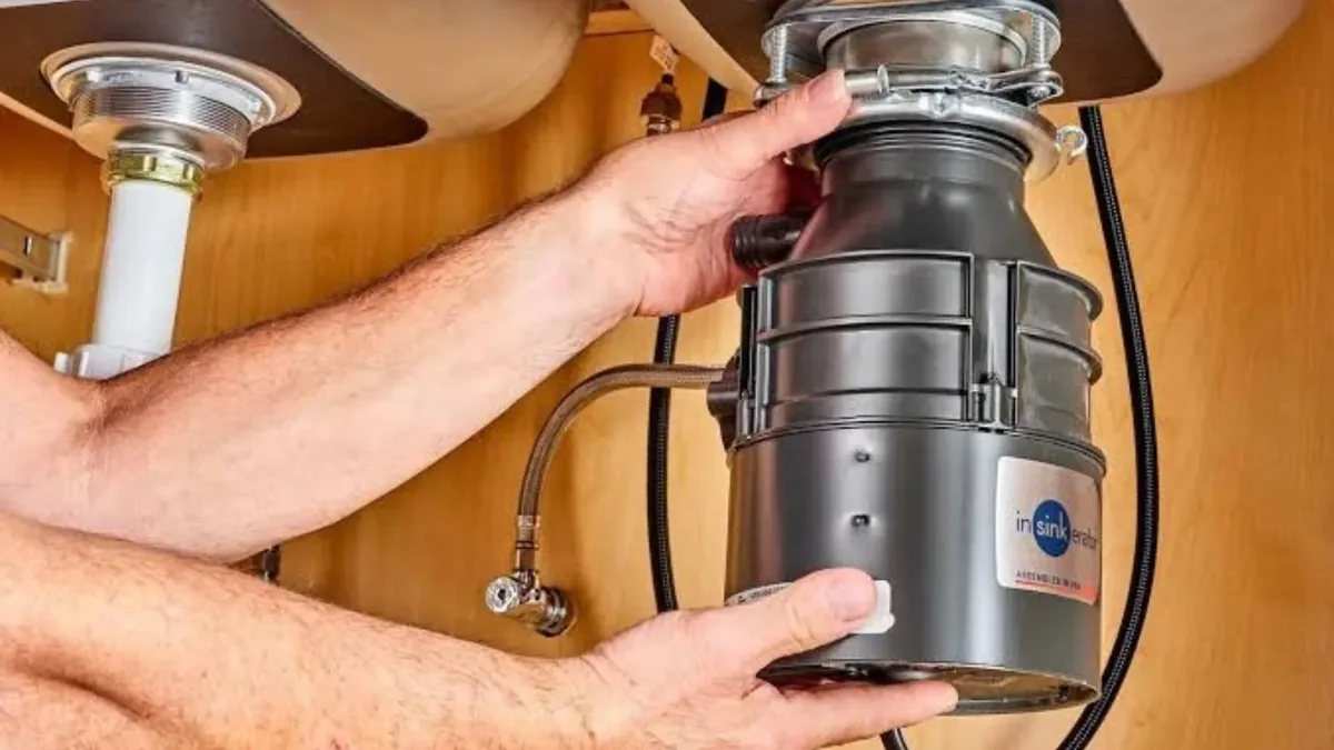 Hands mounting a garbage disposal under a sink